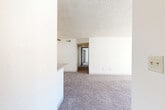 Located in Colorado Springs, CO, this single-floor, 2-bedroom, 3-bathroom home offers a practical and well-organized layout. The living room is carpeted and bright, with natural light streaming through vertical-blind windows and a ceiling fan adding comfort overhead. A textured ceiling is consistent throughout the home, lending a classic character to each room. The combined dining and kitchen area is a standout feature, showcasing grey cabinetry with modern hardware, light countertops, wood-look flooring, and black appliances including a range and refrigerator. A peninsula with additional storage and counter space connects the kitchen to the living and dining areas seamlessly. The primary bedroom is a generously sized, sun-filled retreat with plush carpeting and a connected bathroom. The bathrooms are well-appointed with grey vanity cabinetry, light countertops, mirrored medicine cabinets, and wood-look tile flooring. With three full bathrooms serving two bedrooms, this home provides excellent convenience. Additional features include four closets for ample storage, a hallway connecting all rooms, a utility room, and a private patio—ideal for outdoor relaxation in the Colorado climate.