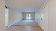 Located at 100 Watts Cir in Nashville, TN, this one-bedroom, two-bathroom residence offers a thoughtfully arranged single-floor layout with a clean, neutral aesthetic throughout. The living room welcomes you with plush carpeting, crown molding, and French doors that open onto a private deck overlooking a lush, tree-lined backdrop — a serene retreat within the city. Light hardwood-style flooring connects the main living areas, creating a seamless flow through the space.

The galley kitchen is well-appointed with white shaker cabinetry, granite countertops, a subway tile backsplash, a stainless steel undermount sink, and stainless steel appliances including a range and refrigerator — offering both functionality and style in a compact footprint.

The spacious primary bedroom features soft carpeting, crown molding, a door with access to natural light, and ample room for furnishings. The two bathrooms are finished with marble-style tile flooring and white subway tile surrounds, providing a clean, timeless look. A hallway connects the private areas of the residence and includes access to a closet for additional storage. The overall ambiance is bright, neutral, and move-in ready.