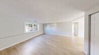 Located at 200 Bedford Rd in Woburn, MA, this two-bedroom, one-bathroom unit offers a well-designed single-floor layout with a cohesive, clean aesthetic throughout. Light hardwood flooring runs continuously across all rooms, complemented by soft gray and white wall tones that create a bright, airy atmosphere.

The spacious living area is highlighted by large windows that invite abundant natural light and feature a textured ceiling that adds subtle architectural character. Two living room areas provide flexible space for various uses. The kitchen is well-appointed with crisp white shaker cabinetry, light quartz countertops, white subway tile backsplash, and a full suite of stainless steel appliances including a gas range, over-the-range microwave, and dishwasher — all illuminated by a window overlooking the exterior.

The primary bedroom is generously sized and includes a large double-door closet, recessed lighting, and a window with outdoor views. The second bedroom also benefits from natural light through a well-positioned window. A connecting hallway links the bedrooms to the full bathroom, which features a white vanity with quartz countertop, subway tile surround, and a mirrored medicine cabinet. The entry area flows seamlessly into the kitchen, making for a practical and functional layout.
