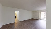 Located at 7 Colony Blvd in Wilmington, Delaware, this single-floor residence offers a well-organized layout designed for comfortable everyday living. The main living area is generously sized, featuring durable wood-look plank flooring and neutral white walls that create a bright, clean atmosphere. A large sliding glass door fitted with vertical blinds allows natural light to fill the space and provides access to the outdoors. The kitchen is thoughtfully appointed with rich dark wood cabinetry, granite-style countertops, a stainless sink, and a dishwasher, complemented by light-toned vinyl flooring and crown molding details. The bedrooms are finished with plush wall-to-wall carpeting and maintain a calm, neutral palette. One bedroom includes a built-in closet with sliding panel doors, while a window with blinds brings in natural light. The bathroom is equipped with a full soaking tub and shower combination, white tile surround, and stainless steel accessibility grab bars for added safety and convenience. Throughout the unit, six-panel interior doors and consistent trim work contribute to a cohesive and tidy aesthetic. The overall layout, as viewed from above, reflects a practical and efficient single-level floor plan suited for a variety of lifestyles.
