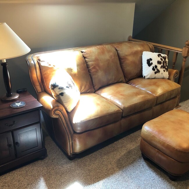 Leather couch with cowhide pillows - 408 3rd Ave. E