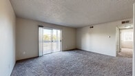 Located at 11310 Melody Dr in Northglenn, Colorado, this single-floor unit offers three bedrooms, one bathroom, a kitchen, and a hallway with closet storage. The layout is efficiently organized, with plush carpeting flowing through the living areas and bedrooms, complemented by textured ceilings throughout. The spacious living room is a standout feature, highlighted by a sliding glass door that opens to a private balcony, allowing natural light to fill the room and providing views of the surrounding neighborhood. The generously sized primary bedroom includes dual windows with blinds that let in ample natural light, and a closet with built-in hanging rods for storage. The additional bedrooms are well-proportioned and each feature windows that bring in natural light. The full bathroom is finished with light wood-look flooring, a white vanity with cabinet storage, and a tub/shower combination. The kitchen features warm wood cabinetry with a tile backsplash and is served by stainless steel appliances. An in-unit washer is conveniently located adjacent to the kitchen area, adding everyday practicality. Light wood-look flooring in the entry and kitchen areas rounds out the cohesive, comfortable interior.