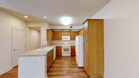 This single-story, 2-bedroom, 2-bathroom home offers a practical and comfortable layout across a well-utilized floor plan. Warm hardwood-style flooring flows throughout the main living areas, lending a cohesive and inviting aesthetic to the space.

The open kitchen and dining area is outfitted with honey-toned wood cabinetry, light countertops, a full suite of white appliances including a refrigerator, range, microwave, and dishwasher, and a double-basin sink. The layout allows for easy interaction between the kitchen and adjoining dining space.

The living room is bright and airy, featuring a ceiling fan with light fixture and clean, neutral walls that provide a versatile backdrop. An entry area with hardwood-style flooring leads naturally into the main living spaces.

Both bedrooms are carpeted for comfort. The primary bedroom is generously sized with an en-suite bathroom, while the second bedroom benefits from multiple windows and a patio door, allowing abundant natural light and outdoor access. Each bathroom includes a wood-toned vanity, mirror, and a tub-shower combination.

A dedicated laundry room houses a full-size washer and dryer with overhead wood cabinetry for added storage. The attached garage provides additional utility space, and three closets throughout the home offer ample storage.