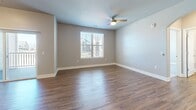 Located in the Ascent community of Colorado Springs, CO, this well-appointed 3-bedroom, 2-bathroom single-floor home offers a thoughtfully designed open-concept layout. Rich hardwood-style flooring flows through the living room and kitchen, creating a warm and cohesive feel. The living room is generously proportioned, featuring a decorative arched niche, sliding glass doors leading to a private balcony, and abundant natural light from multiple windows with neighborhood views.

The kitchen is a standout feature, showcasing dark espresso cabinetry reaching to the ceiling, a subway tile backsplash, stainless steel appliances, and a large center island topped with granite — all illuminated by stylish pendant lighting and a track light system. The three bedrooms are carpeted for comfort, each offering closet space and natural light. The spacious primary bedroom includes hardwood-style flooring, a ceiling fan, and a neighborhood-facing window.

The two bathrooms are finished with granite-topped dark vanities and hardwood-style flooring. One bathroom features a tiled soaking tub/shower combination, while the other includes a glass-enclosed walk-in shower. A dedicated utility room and ample hallway and closet storage round out the practical offerings of this well-equipped home.