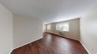 This single-floor, one-bedroom unit at 10568 Hackberry Dr in Saint Louis, MO offers a practical and comfortable layout. The living area is a standout feature, showcasing rich, dark hardwood-style flooring that runs throughout the main space. Two generously sized windows allow abundant natural light to fill the room, offering views of surrounding greenery. A wall-mounted air conditioning unit and baseboard heating provide year-round climate control.

The kitchen is equipped with warm-toned wood cabinetry, light granite-style countertops, and a stainless steel electric range with an overhead ventilation hood, offering a functional and attractive cooking space.

The bedroom is carpeted for comfort and features a large window with blinds that frame tree-lined outdoor views, along with baseboard heating and a closet with full-panel doors providing ample storage.

The bathroom is neatly finished with a wood vanity topped with granite-style countertops, a single sink, and a full tub-shower combination with brushed nickel fixtures. The overall palette throughout the unit is neutral and clean, contributing to a bright, move-in-ready ambiance.