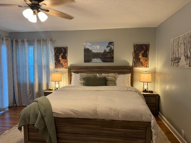 Peaceful primary bedroom with king-sized bed, blackout curtains, and ample storage — your private r - 1117 Henrietta Dr