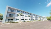 This unit is part of a well-maintained multi-story residential building that makes a strong first impression with its clean, bright white stucco exterior. The building's tropical aesthetic is enhanced by mature palm trees and neatly arranged greenery along the facade, creating an inviting curb appeal. Private balconies with white railings line each level, offering outdoor space and a sense of openness. A dedicated parking area directly in front of the building provides convenient access for residents.

The building's large windows are evenly distributed across the exterior, suggesting that interior spaces are designed to receive ample natural light. The architecture reflects a modern yet relaxed style well-suited to a warm, sun-filled climate.

As a single-floor unit within this complex, the interior layout offers a self-contained living experience. The overall design of the building emphasizes clean lines, practicality, and a light, airy character that complements its tropical surroundings. The combination of the white exterior, palm-lined landscaping, and structured parking area contributes to a cohesive and polished residential environment.