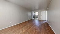 Located at 1530 W Avenue K-8h in Lancaster, CA, this single-floor residence offers 2 bedrooms and 3 bathrooms within a well-organized layout. The open-concept kitchen flows seamlessly into the combined dining and living area, creating a spacious, connected feel. The kitchen is outfitted with white cabinetry, light granite-style countertops, a full suite of white appliances including a gas range, built-in microwave, dishwasher, and refrigerator, plus a double sink. Warm hardwood-style flooring runs throughout the main living spaces, complemented by a ceiling fan overhead. A sliding glass door in the living room opens to a private balcony, allowing natural light to fill the area. Both bedrooms feature plush carpeting and windows that bring in additional daylight. The primary bedroom includes an en-suite bathroom with a granite-topped vanity and hardwood-style flooring. The bathrooms are finished with clean white fixtures and tub-shower combinations with grab bars. Additional conveniences include two closets, a dedicated laundry area, and a hallway connecting the main rooms. The neutral color palette throughout provides a calm, versatile backdrop.