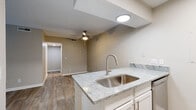 This single-floor residence combines modern updates with functional design throughout its well-organized layout. The open-concept kitchen serves as a central highlight, featuring granite countertops, a peninsula with an undermount stainless steel sink, white shaker-style cabinetry, classic subway tile backsplash, and stainless steel appliances including a refrigerator and electric range. Wood-look luxury vinyl flooring flows seamlessly through the main living areas, lending warmth and continuity to the space.

The living area is bright and inviting, anchored by a ceiling fan and offering access through French doors to an outdoor area, filling the room with natural light and greenery views. The entry foyer offers a clean transition into the open living space, providing a welcoming first impression.

The bedrooms are carpeted for comfort and each includes a ceiling fan with light fixture and windows overlooking lush outdoor scenery, creating a calm, restful atmosphere. The bathroom features a full soaking tub framed by large-format marble-look porcelain tile surround with chrome fixtures, conveying a clean, spa-inspired aesthetic. Wood-look flooring in the bathroom ties it cohesively to the rest of the unit. Neutral warm-beige tones and textured ceilings are consistent throughout, giving the space a cohesive and move-in-ready character.