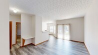 Located at 2680 Silver Oak Dr in Columbus, Ohio, this one-bedroom, one-bathroom unit offers a practical and well-organized single-floor layout. The open-concept living and kitchen area is bright and welcoming, featuring light luxury vinyl plank flooring, warm wood-toned baseboards, and a textured ceiling. A sliding glass door floods the living room with natural light and provides outdoor access, complemented by an additional window that enhances the airy feel of the space. The kitchen is efficiently designed with warm oak cabinetry, white appliances including an electric range and over-the-range microwave, white laminate countertops, and a sink along the pass-through peninsula. A pendant light fixture adds a touch of style to the adjacent dining nook. The bedroom offers a comfortable, carpeted retreat with a natural window, textured ceiling, and access to a dedicated walk-in closet outfitted with wire shelving and hanging rods for generous storage. The bathroom features LVP flooring, a pedestal-style sink, a full mirror, vanity lighting, and accessibility grab bars. Clean neutral tones and consistent finishes throughout give this unit a cohesive and move-in-ready appearance.