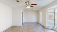 Located at 6550 Lexington Dr in Beaumont, TX, this single-story 2-bedroom, 1-bathroom home offers a thoughtfully designed layout across a generously sized floor plan. The interior features a combination of wood-look hardwood flooring throughout the main living areas and plush carpet in the bedrooms, creating a warm and comfortable atmosphere.

The home includes two distinct living areas, each equipped with ceiling fans and accented by natural light from blinded windows. One living space features a charming bay window that fills the room with an abundance of daylight. Textured ceilings add character throughout.

The galley-style kitchen is a standout, boasting rich dark cabinetry, granite countertops, a stainless steel sink, and black appliances. An elegant chandelier in the adjoining dining area adds a refined touch.

Both bedrooms are spacious and carpeted, each featuring ceiling fans and windows with blinds. The primary bedroom offers a generous footprint with ample room for furnishings. The bathroom continues the granite and dark cabinetry theme, complete with wood-look flooring and a well-appointed vanity. A hallway and dedicated closet space provide additional storage and convenience throughout this comfortable Beaumont home.