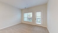 Located at 7800 District Crossing Dr. in Sunbury, Ohio, this one-bedroom, one-bathroom residence offers a thoughtfully designed layout across a single floor. The open-concept living area seamlessly connects the living room, dining space, and kitchen, creating a bright and functional hub for everyday living. The kitchen is well-appointed with dark espresso cabinetry, a white countertop island, stainless steel appliances including a refrigerator, range, microwave, and dishwasher, and warm pendant lighting overhead. Light wood-style flooring runs throughout the kitchen and entry, transitioning to plush carpeting in the living and bedroom areas. The living room is bathed in natural light through large windows and provides direct access to a private balcony with neighborhood views. The generously sized bedroom features multiple windows, allowing for ample natural light. Two closets, including a walk-in with wire shelving, offer substantial storage. The bathroom is clean and modern, featuring a walk-in shower with built-in shelving and wood-look tile flooring. An in-unit laundry area and hallway add to the overall practicality of this well-designed residence.