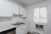 Located at 400 Bruce St in Clearfield, Utah, this two-bedroom, one-bathroom residence is laid out entirely on a single floor, offering a clean and efficient use of space. Throughout the home, light wood-look flooring creates a bright and cohesive aesthetic, complemented by crisp white walls that enhance the overall sense of openness.

The open living area connects seamlessly to the dining room and kitchen, where a stainless steel refrigerator and a gas range are visible. Baseboard heating units line the walls of the living and bedroom spaces, providing consistent warmth. The kitchen and dining area benefit from natural light through a window, adding to the home's airy feel.

Both bedrooms are well-proportioned, each featuring sliding-door closets for convenient storage. The primary bedroom includes a ceiling fan with light fixture and a window overlooking the outdoors. A second bedroom offers its own closet and access to the hallway.

The full bathroom is outfitted with a single-sink vanity with stone-look countertops, a tub/shower combination, and light wood-look flooring consistent with the rest of the home. A dedicated laundry room houses a full-size washer and water heater, complete with wire shelving above. Three closets throughout the unit provide ample additional storage.