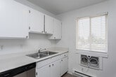 Located at 400 Bruce St in Clearfield, Utah, this two-bedroom, one-bathroom residence is laid out entirely on a single floor, offering a clean and efficient use of space. Throughout the home, light wood-look flooring creates a bright and cohesive aesthetic, complemented by crisp white walls that enhance the overall sense of openness.

The open living area connects seamlessly to the dining room and kitchen, where a stainless steel refrigerator and a gas range are visible. Baseboard heating units line the walls of the living and bedroom spaces, providing consistent warmth. The kitchen and dining area benefit from natural light through a window, adding to the home's airy feel.

Both bedrooms are well-proportioned, each featuring sliding-door closets for convenient storage. The primary bedroom includes a ceiling fan with light fixture and a window overlooking the outdoors. A second bedroom offers its own closet and access to the hallway.

The full bathroom is outfitted with a single-sink vanity with stone-look countertops, a tub/shower combination, and light wood-look flooring consistent with the rest of the home. A dedicated laundry room houses a full-size washer and water heater, complete with wire shelving above. Three closets throughout the unit provide ample additional storage.