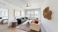 Located at 1225 Utica Dr in Kissimmee, FL, this well-designed single-floor residence offers three bedrooms and two full bathrooms within a thoughtfully laid-out floor plan. The living room features wood-look flooring, a ceiling fan, and a bank of windows that invite natural light and outdoor views, creating an open and airy atmosphere. The kitchen is a functional centerpiece, equipped with dark espresso cabinetry, stainless steel appliances including a refrigerator, range, and microwave, a white quartz countertop, subway tile backsplash, and a spacious island with bar seating illuminated by modern pendant lighting. The primary bedroom is a comfortable retreat with natural light from dual windows and a ceiling fan overhead. The second and third bedrooms share a similarly bright and clean aesthetic. Both bathrooms maintain a consistent modern design, featuring dark wood vanities, white quartz countertops, wood-look tile flooring, and tub-shower combinations with clean white tile surrounds. A dual-sink vanity enhances the primary bath. Throughout the residence, a neutral color palette, clean lines, and consistent wood-look flooring tie all the spaces together into a cohesive, contemporary living environment.