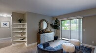 Located at 2167 Ridgecrest Rd SE in Grand Rapids, Michigan, this 2-bedroom, 1-bathroom residence offers a thoughtfully designed single-floor layout that maximizes comfort and functionality. The living room is warm and inviting, featuring plush carpet, built-in corner shelving, and a sliding glass door that opens to a private balcony with lush outdoor views, filling the space with natural light. Adjacent to the living area, the dining room is finished with wood-style flooring, a ceiling fan, a built-in wall shelf, and framed artwork, creating an elegant yet casual atmosphere. The galley-style kitchen is well-equipped with dark cabinetry, white countertops, a subway tile backsplash, stainless steel appliances, and wood-style flooring throughout. The primary bedroom is generously sized and includes in-unit stacked washer and dryer access, adding everyday convenience. The second bedroom offers carpeting, a large window with outdoor views, and versatile space suitable for a home office or guest room. The bathroom features wood-style flooring, a dark vanity with a large mirror, and a shower-tub combination. Neutral tones and clean finishes throughout lend the space a cohesive, modern aesthetic.