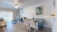 This single-floor residence offers a thoughtfully designed layout that balances comfort and functionality. The open-concept living and dining area serves as the heart of the home, featuring durable wood-look plank flooring, neutral walls, and a ceiling fan that enhances the bright, airy atmosphere. A sliding glass door in the living room allows natural light to flood the space and provides outdoor access, while vertical blinds offer privacy when needed.

The dining area flows seamlessly from the living room and connects directly to the kitchen via a pass-through opening, making entertaining effortless. The kitchen is well-equipped with gray shaker-style cabinetry, white subway tile backsplash, white countertops, and a full suite of stainless steel appliances including a refrigerator, range, and microwave.

The bedrooms are carpeted for comfort and feature ceiling fans, natural light from windows with sheer curtains, and easy access to closet space. The bathrooms are finished with gray vanity cabinetry, wood-look tile flooring, and tub-shower combinations with curtain enclosures, offering a clean and cohesive aesthetic.

Throughout the residence, a consistent coastal-inspired color palette of soft grays, whites, and muted blues creates a calm, welcoming ambiance suited to everyday living.