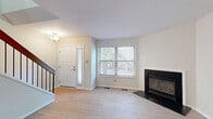 This multi-level residence spans three floors of thoughtfully designed living space, offering 2 bedrooms, 3 full bathrooms, a den, and an impressive total of six closets for ample storage throughout. The main level welcomes residents through a classic paneled front door with sidelight into a bright living room featuring light hardwood-style flooring, neutral walls, and a sleek fireplace with a black surround and hearth — a clear focal point of the space. A pass-through window connects the living area to the combined dining and kitchen space, which is outfitted with white shaker cabinetry, granite countertops, subway tile backsplash, and a full suite of stainless steel appliances. An adjacent pantry and secondary exterior door add convenience to the kitchen area. The bathrooms are finished with white cabinetry, granite-topped vanities, and tub-shower combinations with light wood-look tile flooring. The bedrooms feature plush carpet and generous closet space, with the primary bedroom offering multiple closets. Additional functional spaces include a dedicated laundry room, utility room, and a den. Each floor maintains a consistent, clean aesthetic with neutral tones throughout, creating a cohesive and move-in-ready living environment.