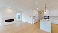 Located at 110 Chatsworth Ave in Larchmont, NY, this meticulously designed single-floor residence showcases a clean, contemporary aesthetic defined by crisp white walls, light hardwood flooring, and recessed lighting throughout. The open-concept living and dining area centers around a sleek fireplace framed by a stone surround, with natural light streaming through large windows and offering views of the surrounding neighborhood.

The chef's kitchen is a standout feature, outfitted with high-gloss white cabinetry, a large quartz waterfall island with an undermount sink, stainless steel appliances including a gas range, double wall ovens, and a refrigerator, all complemented by brass pendant lighting overhead. A secondary cabinetry zone provides additional storage and workspace.

The primary suite includes a spacious walk-in closet with a fully customized shelving and drawer system, and a luxurious en-suite bathroom featuring floor-to-ceiling marble tile, a glass-enclosed shower with a rain head, and clean chrome fixtures. A secondary bathroom offers a soaking tub with subway tile surround and a modern floating vanity. Additional bedrooms are generously proportioned with hardwood floors and ample natural light.