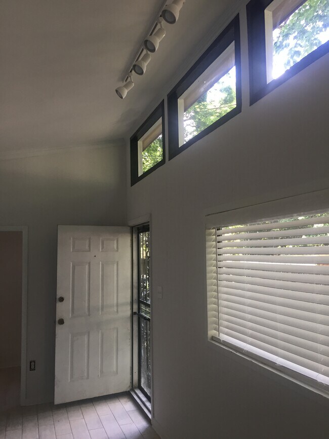 Ventanales con molduras negras, iluminación en riel y persianas de imitación madera de 5 cm. Puerta principal que da al patio. - 1742 N Parkway