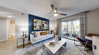 Located at 1737 S Clyde Morris Blvd in Daytona Beach, FL, this 2-bedroom, 1-bathroom residence offers a thoughtfully designed single-floor layout with modern finishes throughout. Wood-look flooring flows seamlessly across the entire unit, lending a cohesive and contemporary feel.

The living room is a standout space, anchored by a bold navy accent wall that frames a ceiling fan and large sliding glass doors, which flood the room with natural light and provide views of lush greenery outside. The open, airy feel makes it an inviting area for relaxing or entertaining.

The kitchen is well-equipped, featuring white shaker cabinetry, granite-style countertops, a classic subway tile backsplash, and a full suite of stainless steel appliances including a range, microwave, dishwasher, and refrigerator. In-unit laundry is also conveniently located nearby.

The primary bedroom offers a comfortable retreat with a ceiling fan, a dedicated closet, and soft neutral tones. The second bedroom mirrors a similarly calm aesthetic with a tray ceiling detail and natural light from a large window. The bathroom is clean and functional, featuring a granite-topped vanity with white cabinetry and a shower-tub combination. Two closets provide ample storage throughout the home.