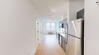 Located on the sixth floor at 300 E Main St in Bound Brook, NJ, this thoughtfully designed one-bedroom, one-bathroom residence offers a clean, contemporary aesthetic throughout. Light wood-tone flooring runs continuously across the open layout, creating a warm and cohesive feel from entry to living area.

The galley-style kitchen is a standout feature, equipped with sleek gray cabinetry, white countertops, and a full suite of stainless steel appliances including a refrigerator, electric range, built-in microwave, and dishwasher. Track lighting overhead keeps the space bright and functional. A stacked washer and dryer unit adds in-unit laundry convenience.

The bedroom is a serene retreat with soft neutral wall tones, warm wood flooring, a double-door closet offering generous storage, and a large window that frames elevated views of the Bound Brook skyline and surrounding hills, filling the room with natural light.

The bathroom features a frameless glass-enclosed walk-in shower clad in large-format white tiles with polished chrome fixtures, delivering a spa-like, minimalist finish.

The open living area flows naturally from the kitchen, benefiting from a window at the far end that draws in additional natural light. Clean white walls, modern black hardware, and consistent finishes throughout give this residence a polished, move-in-ready appeal.