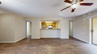 This well-appointed single-floor residence in Largo, Florida offers a thoughtfully designed layout spanning just over 1,000 square feet. The open-concept living and dining area serves as the heart of the home, featuring durable wood-look laminate flooring, a ceiling fan with light fixture, and a sliding glass door that fills the space with natural light and provides direct access to a private outdoor patio. A pass-through counter connects the living area to the kitchen, which is equipped with wood cabinetry, dark granite-style countertops, and stainless steel appliances, creating an efficient and functional cooking space. A dedicated hallway leads to the spacious primary bedroom, which is appointed with plush wall-to-wall carpeting, a ceiling fan, and a window with blinds that allow for natural light. The bedroom provides convenient access to both a full bathroom and a dedicated closet. The bathroom features wood-look flooring, a toilet, and a tub-shower combination. Throughout the residence, neutral warm-toned walls and white trim create a clean, cohesive aesthetic. The layout is complemented by ample ventilation with HVAC vents throughout, making this a comfortable and functional home in the heart of Largo.