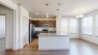 This thoughtfully designed 2-bedroom, 2-bathroom residence offers a comfortable and functional layout across a single floor. Wood-style plank flooring flows seamlessly throughout the space, providing a cohesive and modern aesthetic.

The open-concept kitchen and living area serves as the heart of the home. The kitchen is outfitted with rich dark cabinetry, granite countertops, and a full suite of stainless steel appliances, including a refrigerator, range, and microwave. A central island with a built-in sink and pendant lighting above adds both style and practicality, while multiple windows invite abundant natural light and outdoor views.

Both bedrooms are generously sized, each featuring ceiling fans, wide windows with outdoor views, and wood-style flooring. The primary bedroom offers a comfortable footprint with ample closet storage. The two bathrooms are finished with granite-topped dark vanities and wood-style flooring. The primary bath includes a walk-in shower with glass doors, while the secondary bath features a full soaking tub and shower combination with tile surround.

Additional hallways and dedicated closets throughout the unit provide excellent storage. The clean, neutral color palette and consistent finishes create a bright, inviting ambiance throughout the entire space.