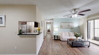 Located at 11247 San Jose Blvd in Jacksonville, FL, this single-floor residence offers three bedrooms and three bathrooms with a thoughtfully designed layout. The combined kitchen and living area serves as the heart of the home, where wood-look plank flooring flows throughout. The kitchen is equipped with rich dark cabinetry, granite-style countertops, stainless steel appliances, and a dedicated walk-in pantry with built-in wire shelving for ample storage. The living room features a ceiling fan, a sliding glass door that draws in natural light and provides outdoor access, and a warm, neutral color palette with soft sage accent walls. The entryway opens to a defined dining area, maintaining a functional yet open feel. Each bedroom is carpeted and finished with the same soothing sage accent walls, with the primary bedroom offering dual windows and a ceiling fan. The bathrooms are well-appointed with dark vanity cabinetry, granite-style countertops, and wood-look flooring. One bathroom features a split layout with a separate water closet. Textured ceilings are consistent throughout, and the overall design reflects a clean, modern aesthetic suited for comfortable everyday living.