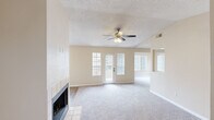 Located in Chandler, Arizona, this well-appointed 1-bedroom, 1-bathroom single-floor unit offers a thoughtfully designed layout that maximizes comfort and functionality. The open living room serves as the heart of the home, showcasing vaulted ceilings, a textured ceiling finish, a ceiling fan with light kit, and a tile-surround wood-burning fireplace as a standout focal point. Soft carpeting extends throughout the living and bedroom areas, while wood-look vinyl flooring runs through the kitchen and bathroom. Natural light fills the space through multiple windows with vertical blinds and a glass-paneled exterior door leading to a private patio. The kitchen features white cabinetry, light stone countertops, stainless steel appliances including a full-size refrigerator, and a bright window overlooking the outdoors. The generously sized bedroom includes its own ceiling fan, a large window, and direct access to a walk-in closet with dual hanging rods and a built-in shelving unit for ample storage. The bathroom is equipped with a single vanity with stone countertop and a full tub/shower combination. A tiled entrance foyer completes the layout, providing a clean transition into the living space.