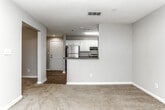 Located at 900 Meadow Glen Pkwy in Fairburn, Georgia, this single-floor residence offers a well-organized layout designed for comfortable everyday living. The galley-style kitchen is a functional highlight, featuring white cabinetry, dark granite-style countertops, a stainless steel sink, and appliances including an electric range and dishwasher. Wood-look flooring runs through the kitchen, adding warmth and easy maintenance to the space. Natural light filters in through a slatted window blind, brightening the room throughout the day. The bedrooms are finished with soft, neutral carpet and light-toned walls, creating a calm and inviting atmosphere. One bedroom features a walk-in closet with built-in shelving, offering generous storage capacity. A ceiling fan with a light fixture adds comfort and functionality. The bathroom is clean and straightforward, with wood-look flooring, a full soaking tub and shower combination with white tile surround, and classic white fixtures. The open-concept doll's-eye view reveals a cohesive flow between the living, dining, and kitchen areas, with a sliding glass door drawing in natural light from outside. Overall, the space presents a tidy, move-in-ready environment with practical finishes throughout.