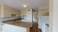 This two-story, 2-bedroom, 2-bathroom home provides a well-organized layout designed for comfortable everyday living. The main level features a kitchen equipped with white cabinetry, laminate countertops, a double sink, a white electric range, refrigerator, and dishwasher. A peninsula-style counter extends into the space, offering additional prep area and a natural separation between the kitchen and the adjoining living areas. Wood-look flooring runs throughout the main level, adding warmth and durability. A staircase leads to the upper level, where both bedrooms are located. Each bedroom is carpeted for comfort and features a ceiling fan with light fixture and window with blinds, allowing for natural light and ventilation. The two full bathrooms serve the home efficiently — one features a soaking tub and shower combination with wood-look flooring, while the second includes a vanity with a large mirror and under-sink storage. Neutral, warm-toned walls throughout create a cohesive and inviting atmosphere. Textured ceilings add a classic touch to the interior. The overall design is clean, practical, and move-in ready, making this home a solid choice for those seeking straightforward, functional living across two thoughtfully arranged floors.