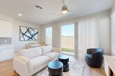 Located at 7951 W Whitney Dr in Peoria, AZ, this well-appointed two-story home offers 2 bedrooms and 3 bathrooms across two thoughtfully designed floors. The main level features an open-concept living room and kitchen, filled with natural light through large sliding glass doors that open to a backyard view. Light hardwood-style flooring runs throughout, complemented by clean white walls and modern ceiling fans. The kitchen is equipped with stainless steel appliances, crisp white shaker cabinetry, a gray tile backsplash, and generous counter space. A convenient half-bath is also located on the main floor. A wood-tread staircase leads to the upper level, where both bedrooms reside. The primary bedroom includes a walk-in closet and an en-suite bathroom with a well-lit vanity. The second bedroom is bright and airy, with multiple windows offering neighborhood views. A full bathroom with a tiled tub-shower combo and wood-look flooring serves the upper level. The attached two-car garage provides ample storage and parking. The home's modern, neutral aesthetic creates a clean, comfortable ambiance throughout.