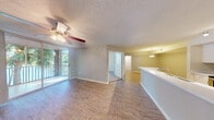 This single-floor residence offers a thoughtfully designed layout with a seamless flow between the main living and dining areas. Wood-look flooring runs throughout the common spaces, complemented by neutral-toned walls and textured ceilings fitted with ceiling fans for year-round comfort. Large sliding glass doors in the living area and primary bedroom flood the space with natural light and provide direct access to a private balcony overlooking lush tropical greenery.

The kitchen is equipped with stainless steel appliances — including a refrigerator, range, and microwave — white cabinetry, a decorative tile backsplash, track lighting, and a wraparound breakfast bar that connects effortlessly to the living space. Adjacent to the kitchen, a dedicated laundry area houses in-unit washer and dryer units for added convenience.

The bedrooms feature plush carpeting and generous walk-in or reach-in closet space. The bathroom is finished with clean white tile flooring and a full tub-shower combination. Throughout the residence, clean lines, bright finishes, and a consistent neutral palette create a light, airy ambiance that is both functional and welcoming.