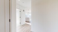 Located at 6901 Flying Cloud Dr in Eden Prairie, MN, this thoughtfully designed 2-bedroom, 3-bathroom residence offers a clean, modern aesthetic across a well-appointed single-floor layout. The entrance leads through a bright hallway into an open-concept living and kitchen area bathed in natural light. The expansive living room is anchored by large floor-to-ceiling windows and a sliding glass door that opens to a private balcony, offering sweeping outdoor views and generous sunlight throughout the day. Light hardwood flooring flows seamlessly across the main living areas. The kitchen is a standout feature, showcasing white shaker cabinetry, a granite-topped center island with pendant lighting, stainless steel appliances, and a classic tile backsplash — ideal for both everyday cooking and entertaining. Both bedrooms are carpeted for comfort, each receiving ample natural light through sizable windows with outdoor views. The primary bedroom is generously proportioned and supported by its own well-appointed bathroom. The three bathrooms share a consistent design language, featuring white cabinetry with stone countertops, wood-look tile flooring, and matte black hardware and fixtures. Two closets provide practical storage, completing this polished and functional residence.