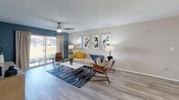 This single-floor residence offers a cohesive, modern aesthetic across its well-organized layout. The living room serves as a central gathering space, featuring wood-look laminate flooring, a ceiling fan, and a striking teal accent wall. A sliding glass door fills the room with natural light and provides outdoor access, creating an inviting, airy atmosphere.

The kitchen is thoughtfully equipped with white cabinetry, dark countertops, stainless steel appliances, and a classic subway tile backsplash. Natural light filters in through a window, enhancing the clean, functional design. Adjacent to the kitchen, the dining area accommodates a round table with modern white chairs beneath a contemporary drum pendant light.

Multiple bedrooms provide comfortable retreats, each featuring plush carpet flooring and ceiling fans. The primary bedroom stands out with a bold teal accent wall and a window allowing natural light. Additional bedrooms maintain a neutral palette with ample space for furnishings.

The bathrooms offer tub-shower combinations with curtains, white cabinetry with dark countertops, and well-lit vanity mirrors. Throughout the residence, a consistent neutral color palette punctuated by teal accents creates a cohesive, modern living environment.