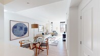 Located at 1315 W St NW in Washington, DC, this apartment offers a well-designed single-level layout in the heart of the U Street neighborhood. The open-concept living and dining area is bathed in natural light, courtesy of large, floor-to-ceiling windows that frame views of the surrounding cityscape. Light hardwood flooring runs throughout the main living space, complementing the clean white walls and creating a bright, airy atmosphere. The living area provides ample room for seating and entertaining, while the dedicated dining space accommodates a full dining set with ease. The kitchen is outfitted with dark espresso cabinetry, stainless steel appliances including a full-size refrigerator, electric range, and built-in microwave, along with a subway tile backsplash and light countertops. Both bedrooms feature large windows that invite abundant natural light and offer views of the neighborhood's distinctive brick architecture. The full bathroom includes a soaking tub with shower combination, white tile surround, a dark wood vanity with a white countertop, and a convenient stacked in-unit washer and dryer. The overall design balances modern finishes with a clean, functional aesthetic throughout.