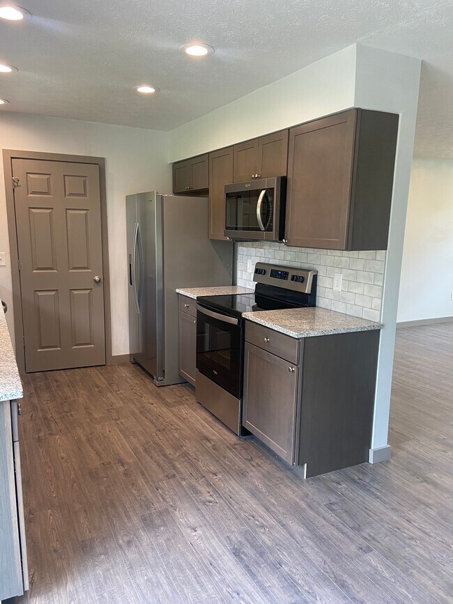 Remodeled Kitchen with granite counters, tile backsplash, and new appliances - 174 Brisbane Ave