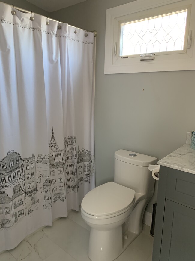 Full Bathroom has a shower and tub with a window and fan. Radiant granite floor heat with thermostat. Granite counter top and floor. New towels. - 97 Washington street