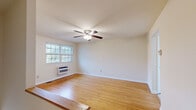 This well-organized single-floor home offers 2 bedrooms, 1 bathroom, and a practical layout that makes efficient use of its space. Warm-toned hardwood flooring runs throughout the living areas and both bedrooms, lending a cohesive and inviting feel to the interior. Each room is fitted with a ceiling fan with integrated lighting, contributing to both comfort and energy efficiency.

The living room is bright and open, featuring a wall-mounted HVAC unit and a window that allows natural light to fill the space. The primary bedroom is a comfortable size and includes a closet with a hanging rod, along with a window framing outdoor views. The second bedroom mirrors this layout with its own window and ceiling fan, offering a similarly clean and functional space.

The kitchen is equipped with ample cabinetry in a warm neutral finish, dark countertops with a tile backsplash, and white appliances including a gas range, refrigerator, and dishwasher. A window above the sink brings in natural light. Light ceramic tile flooring grounds the kitchen area.

The bathroom features warm beige tile work on both the floors and walls, with a full tub and shower combination, a window for ventilation, and a clean, classic design. Additional utility is provided by a hallway and a closet, along with a utility area housing an electrical panel.