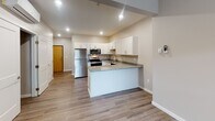 Located at 24 Eighth St N in Fargo, North Dakota, this well-appointed single-floor unit offers a clean, modern aesthetic with an open-concept design that connects the kitchen and living areas seamlessly. The kitchen is a standout feature, showcasing white shaker-style cabinetry, granite countertops, a peninsula that provides additional prep and seating space, and a full suite of stainless steel appliances including a refrigerator, electric range, microwave, and dishwasher. Recessed lighting illuminates the kitchen, while wood-look plank flooring extends throughout the entire unit, adding warmth and cohesion to the space. The living area is generously sized and benefits from natural light through a window, complemented by a ceiling fan for added comfort. A wall-mounted mini-split unit provides efficient climate control. Storage is well considered, with a walk-in closet featuring built-in wire shelving. The bathroom is neatly finished with a granite-topped vanity, matching white cabinetry, wood-look flooring, and a full tub-shower combination. Baseboard heating runs along the living area walls, and a solid entry door with natural wood finish provides a welcoming touch at the entrance. The overall ambiance is fresh, contemporary, and move-in ready.