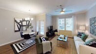 This 2-bedroom, 2-bathroom single-floor residence offers a thoughtfully designed layout with modern finishes and a warm, inviting ambiance. The open-concept kitchen is a standout feature, showcasing dark espresso cabinetry, granite countertops, a subway tile backsplash, and stainless steel appliances. A granite-topped breakfast bar with pendant lighting provides additional seating and connects the kitchen to the main living area. The living and dining spaces are generously sized, featuring rich hardwood-style flooring, crown molding, a ceiling fan, and multiple windows that invite abundant natural light. A door leads to an outdoor area, enhancing the sense of openness. Both bedrooms are comfortably proportioned with plush carpeting and ceiling fans. The primary bedroom includes a walk-in closet and an en-suite bathroom, while the second bedroom offers easy access to the additional full bath. Each bathroom is well-finished, with one featuring a soaking tub and shower combination accented by classic white subway tile. Throughout the residence, neutral tones and consistent design choices create a cohesive and contemporary aesthetic.