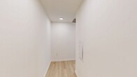 Located on the 11th floor at 258 S Harrison St in East Orange, NJ, this modern 2-bedroom, 1-bathroom residence combines contemporary design with sweeping elevated views of the surrounding cityscape and lush treetops. Light wood flooring runs throughout the unit, creating a warm, cohesive aesthetic against the crisp white walls and clean-lined architecture.

The open-concept kitchen and living area serves as the heart of the home. The kitchen is outfitted with sleek, dark-toned cabinetry with glass-front upper cabinets, a striking marble-look quartz waterfall island, white quartz countertops, a minimalist tile backsplash, and a full suite of stainless steel appliances including a range, dishwasher, microwave, and refrigerator. Track lighting above adds a modern, gallery-like quality.

The living area benefits from expansive floor-to-ceiling windows fitted with roller shades, flooding the space with natural light and framing panoramic views of the East Orange skyline and surrounding greenery.

The generously sized primary bedroom also enjoys floor-to-ceiling windows with the same stunning elevated views. The second bedroom is a comfortable, well-proportioned space with light flooring and ample wall space. The bathroom features a full soaking tub surrounded by bold, large-format dark tile, offering a sharp contrast to the otherwise light and airy palette of the home.