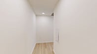 Located on the 11th floor at 258 S Harrison St in East Orange, NJ, this modern 2-bedroom, 1-bathroom residence combines contemporary design with sweeping elevated views of the surrounding cityscape and lush treetops. Light wood flooring runs throughout the unit, creating a warm, cohesive aesthetic against the crisp white walls and clean-lined architecture.

The open-concept kitchen and living area serves as the heart of the home. The kitchen is outfitted with sleek, dark-toned cabinetry with glass-front upper cabinets, a striking marble-look quartz waterfall island, white quartz countertops, a minimalist tile backsplash, and a full suite of stainless steel appliances including a range, dishwasher, microwave, and refrigerator. Track lighting above adds a modern, gallery-like quality.

The living area benefits from expansive floor-to-ceiling windows fitted with roller shades, flooding the space with natural light and framing panoramic views of the East Orange skyline and surrounding greenery.

The generously sized primary bedroom also enjoys floor-to-ceiling windows with the same stunning elevated views. The second bedroom is a comfortable, well-proportioned space with light flooring and ample wall space. The bathroom features a full soaking tub surrounded by bold, large-format dark tile, offering a sharp contrast to the otherwise light and airy palette of the home.