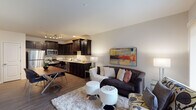 Located at 1823 Covington Ct in St. Charles, Illinois, this single-floor residence offers a thoughtfully designed open-concept layout that seamlessly connects the main living areas. The kitchen is a standout feature, outfitted with rich dark espresso cabinetry, granite countertops, stainless steel appliances including a refrigerator, microwave, and gas range, and a track lighting system overhead. An adjacent dining area provides an ideal setting for meals, with hardwood-style flooring flowing throughout the common areas. The living room is bright and welcoming, anchored by a large sliding glass door that fills the space with natural light and offers views of the greenery outside. The bedroom is generously sized, featuring plush carpeting, multiple windows that invite natural light, and access to a spacious walk-in closet with built-in shelving. The bathroom is finished with granite countertops, dark cabinetry, and clean, neutral tones that lend a polished, understated elegance. Throughout the residence, neutral wall colors and quality finishes create a cohesive and comfortable ambiance, making this St. Charles home a well-balanced blend of style and functionality.
