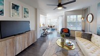 Located at 384 Treeline Park in San Antonio, TX, this thoughtfully designed single-floor residence offers a seamless blend of modern finishes and curated style throughout. The open-concept living area features dark hardwood-style flooring, a ceiling fan, and large windows that invite abundant natural light and views of surrounding greenery. A dedicated dining nook with an oversized window provides a bright, comfortable setting for meals. The kitchen is well-appointed with white cabinetry, quartz countertops, a herringbone tile backsplash, stainless steel appliances including a range, microwave, and dishwasher, and a peninsula that connects to the living space. The primary bedroom offers plush carpeting, a ceiling fan, and striking wall art, complemented by an en suite bathroom featuring a quartz vanity, large mirror, and a glass-enclosed shower. The second bedroom is equally inviting, with natural light filtering through blinds and warm-toned curtains. A secondary bathroom includes a clean white tiled tub-shower combination and wood-style flooring. Throughout the residence, intentional design choices and quality finishes create a cohesive, contemporary ambiance ideal for modern living.