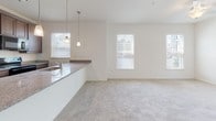Located at 34011 Harvard Ave in Millsboro, Delaware, this single-floor home offers a thoughtfully designed open-concept layout that seamlessly connects the kitchen, dining, and living areas. The kitchen is a standout feature, showcasing rich dark wood cabinetry, granite countertops, and a large island with a built-in sink and pendant lighting overhead. Black appliances, including a French door refrigerator and electric range, complete the functional and stylish space. Wood-look flooring runs through the entryway and kitchen, while plush neutral carpeting extends throughout the living area and bedrooms, adding warmth and comfort underfoot. The bright and airy living room is filled with natural light from multiple windows and features a ceiling fan, with French doors opening to a lush outdoor view. The bedrooms are generously sized, each equipped with ceiling fans, ample closet space, and large windows that invite in natural light. The bathroom is well-appointed with dark wood vanity cabinetry, a glass-enclosed walk-in shower, wood-look flooring, and clean white finishes throughout. The overall ambiance of the home is bright, clean, and move-in ready, offering a comfortable and modern living experience in a single-level setting.