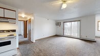 Located at 1866 Lee Blvd in North Mankato, MN, this single-floor, 3-bedroom, 1-bathroom unit offers a practical and functional layout. The living room is a comfortable, open space featuring plush carpeting, a ceiling fan, a wall AC unit, and a large sliding glass door that fills the room with natural light and provides views of the surrounding neighborhood's mature trees. Baseboard heating runs throughout the unit, ensuring warmth during Minnesota winters.

The kitchen is well-equipped with ample white cabinetry accented by wood trim, a full suite of white appliances including a refrigerator, electric range, and dishwasher, and a tile floor that extends into the entryway. The entry area also features a conveniently located electrical panel.

The three bedrooms are carpeted and bright, each benefiting from natural light through windows. The primary bedroom is generously sized and includes a large sliding-door closet. Additional bedrooms offer wall AC units and baseboard heating for year-round comfort.

The full bathroom is finished with tile flooring, a single-sink vanity with white cabinetry, and a tub-shower combination. The overall design is clean and straightforward, offering a practical living environment in a residential North Mankato neighborhood.