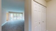 This 970 square foot apartment in Newport Village offers a well-designed living space with two bedrooms and one bathroom. The layout maximizes functionality with an open-concept design that seamlessly integrates the living, dining, and kitchen areas.

The kitchen is a highlight, featuring crisp white cabinetry, stainless steel appliances, and a gas range. The wood-look vinyl flooring in the kitchen adds warmth and durability. Adjacent to the kitchen is a convenient laundry area with a full-sized washer and dryer.

Both bedrooms are generously sized, with the primary bedroom measuring 170 square feet. Plush carpeting in the bedrooms and living areas provides comfort underfoot. Large windows in every room flood the space with natural light and offer views of the surrounding area.

The bathroom is well-appointed with neutral tiled walls, a full-sized tub with shower, and a modern toilet. Throughout the apartment, recessed lighting and ceiling fixtures provide ample illumination.

The living room is particularly spacious, featuring a large sliding glass door that leads to an outdoor space, further expanding the living area and allowing for seamless indoor-outdoor living.

With its neutral color palette, this apartment provides a blank canvas for personalization while offering modern amenities and a thoughtful layout designed for comfortable living.