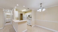 Located at 121 Margie Dr in Warner Robins, Georgia, this single-story home offers a generous and thoughtfully laid-out floor plan across one level. The interior is finished in warm, neutral tones throughout, creating a cohesive and inviting ambiance from room to room.

The main living area is expansive, featuring soft carpet flooring, elegant crown molding, and a ceiling fan with light fixture. Natural light filters in through blinds-fitted windows and a glass-paned door that opens to the outdoors, enhancing the open feel of the space.

The kitchen is well-appointed with white cabinetry, a built-in microwave, electric range, and a full-size refrigerator. A peninsula with a sink adds functional counter space, while recessed lighting and a decorative chandelier over the adjacent dining area lend a polished touch. Crown molding and tile flooring complete the kitchen's clean aesthetic.

The bedroom is a comfortable retreat with plush carpet, crown molding, a ceiling fan, and dual windows that invite natural light and outdoor views.

The bathroom features tile flooring, a tub-shower combination with a curtain rod, a toilet, vanity with storage, and a window for natural ventilation. A dedicated laundry room includes tile flooring, washer/dryer hookups, and overhead wire shelving for additional storage. A separate closet provides further organizational space.